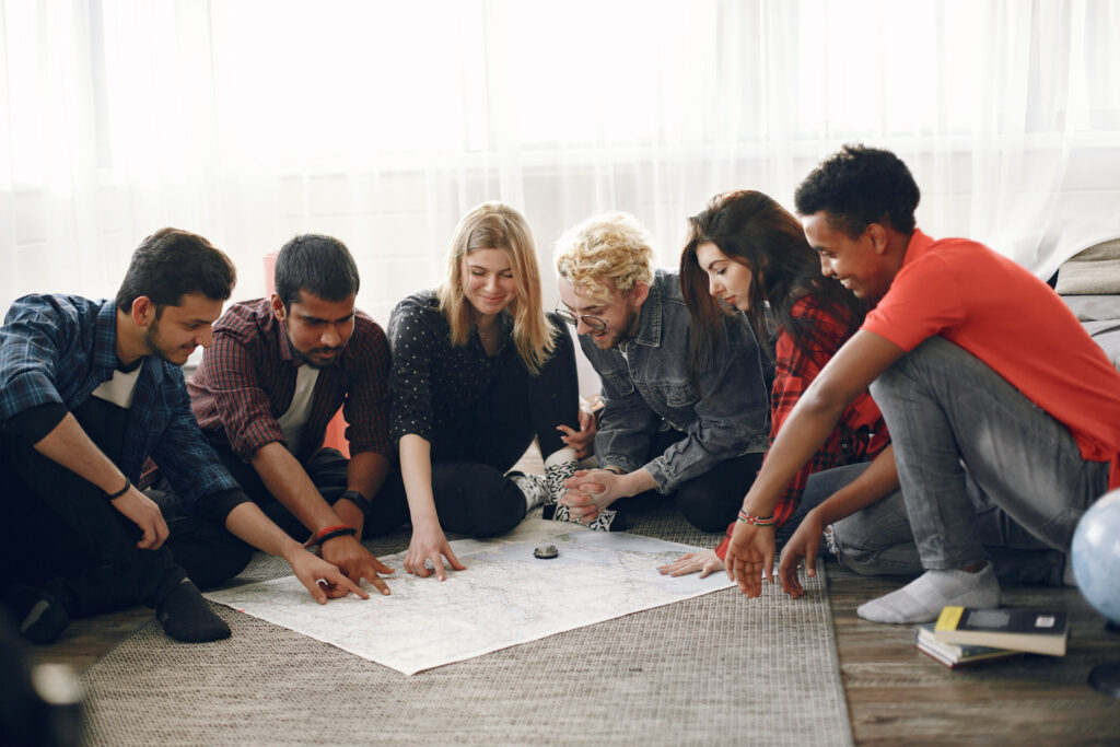 group of diverse friends looking at map in the bright room