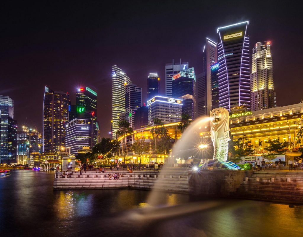 Dazzling view of the Singapore cityscape with Merlion and illuminated skyscrapers at night.
